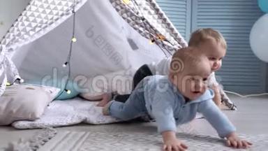 可爱的婴儿拍手，摔在地板上。 <strong>二胎</strong>爬过他身边